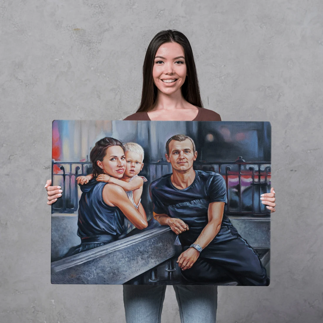 A woman holds a portrait of two adults and a small child.