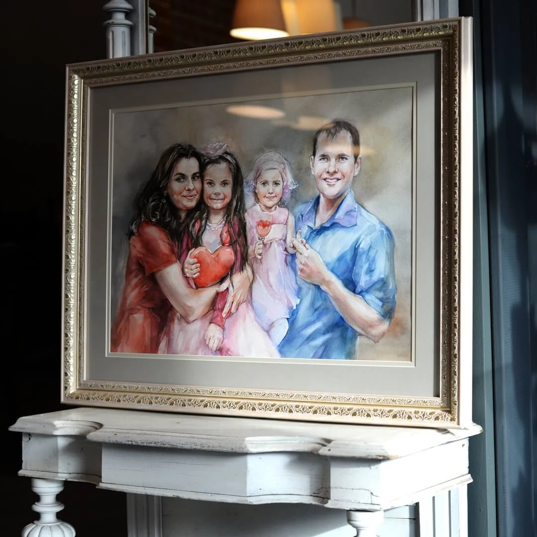 A portrait of two adults and two children in a decorative frame beside a window.